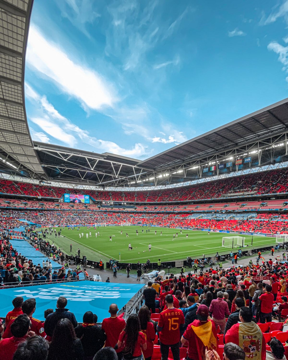 Packed football stadium during a match on a sunny day