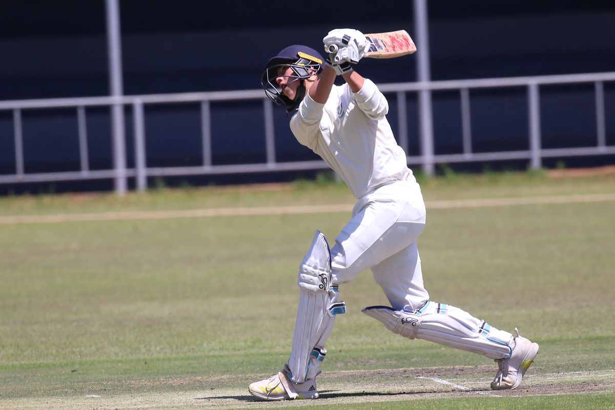 Cricket batsman playing a powerful shot on an outdoor field