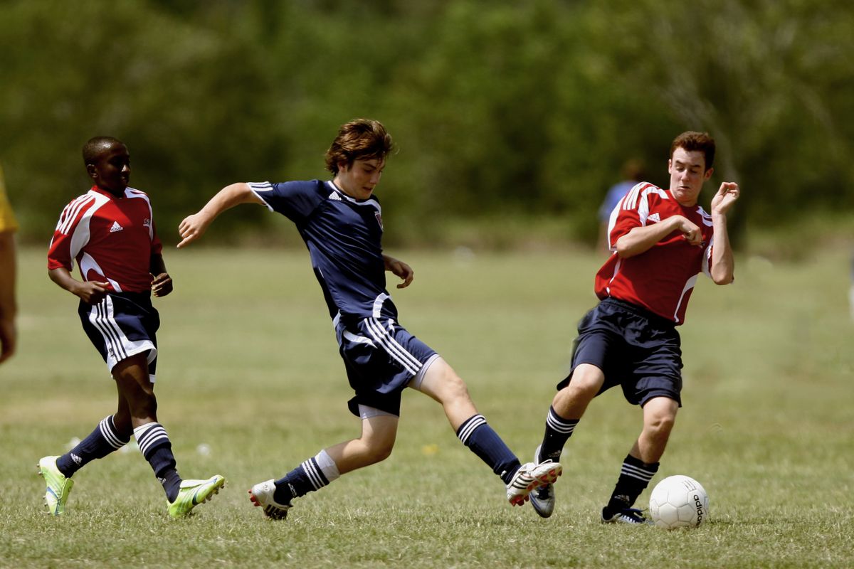 Youth football players competing for the ball during an outdoor match