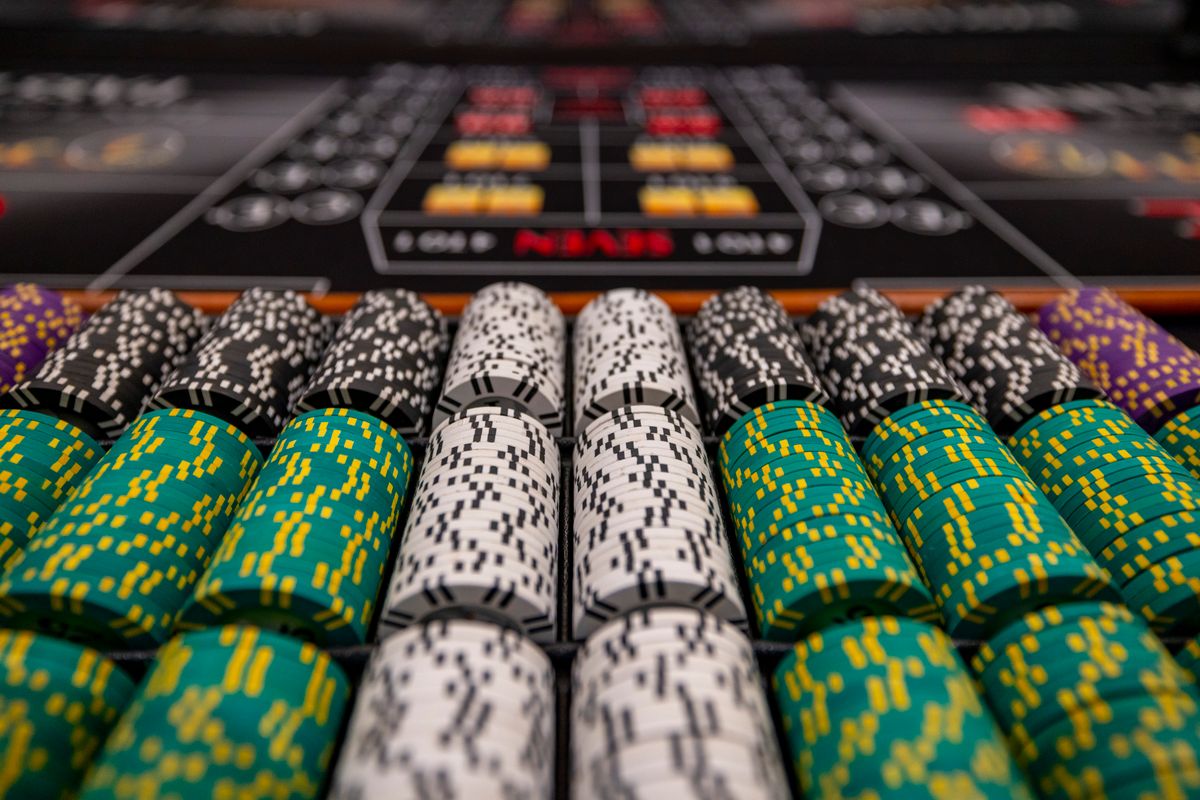Stacks of green, white and black casino chips arranged on a gaming table