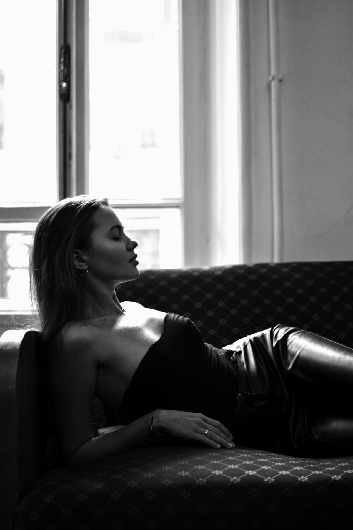 A person relaxing on a sofa in a dimly lit room