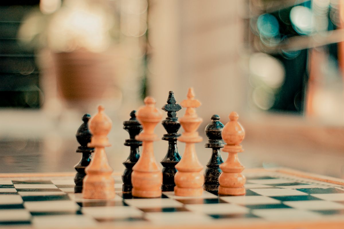 Chess pieces standing on a chessboard with a blurred background
