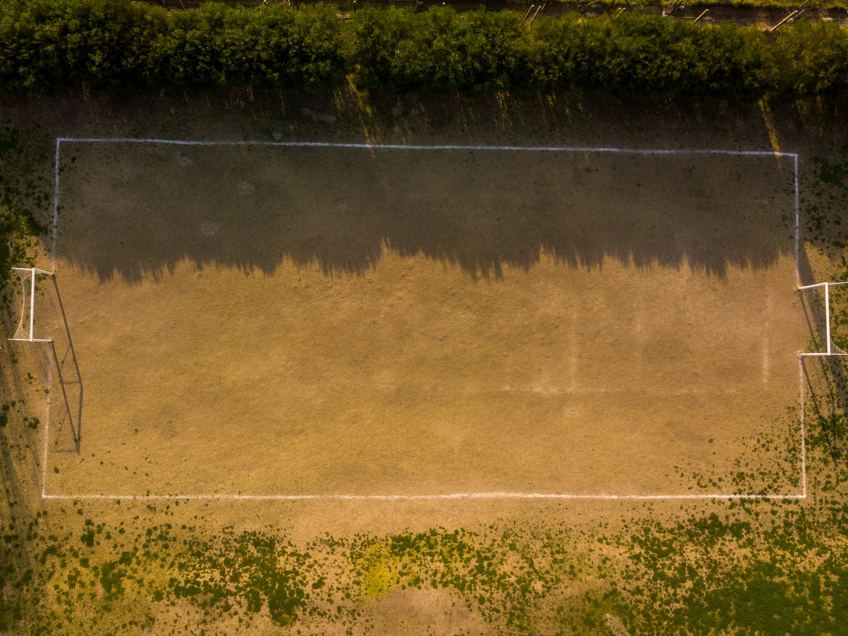 Drone shot of an empty soccer field in Buenos Aires showing light and shadow play