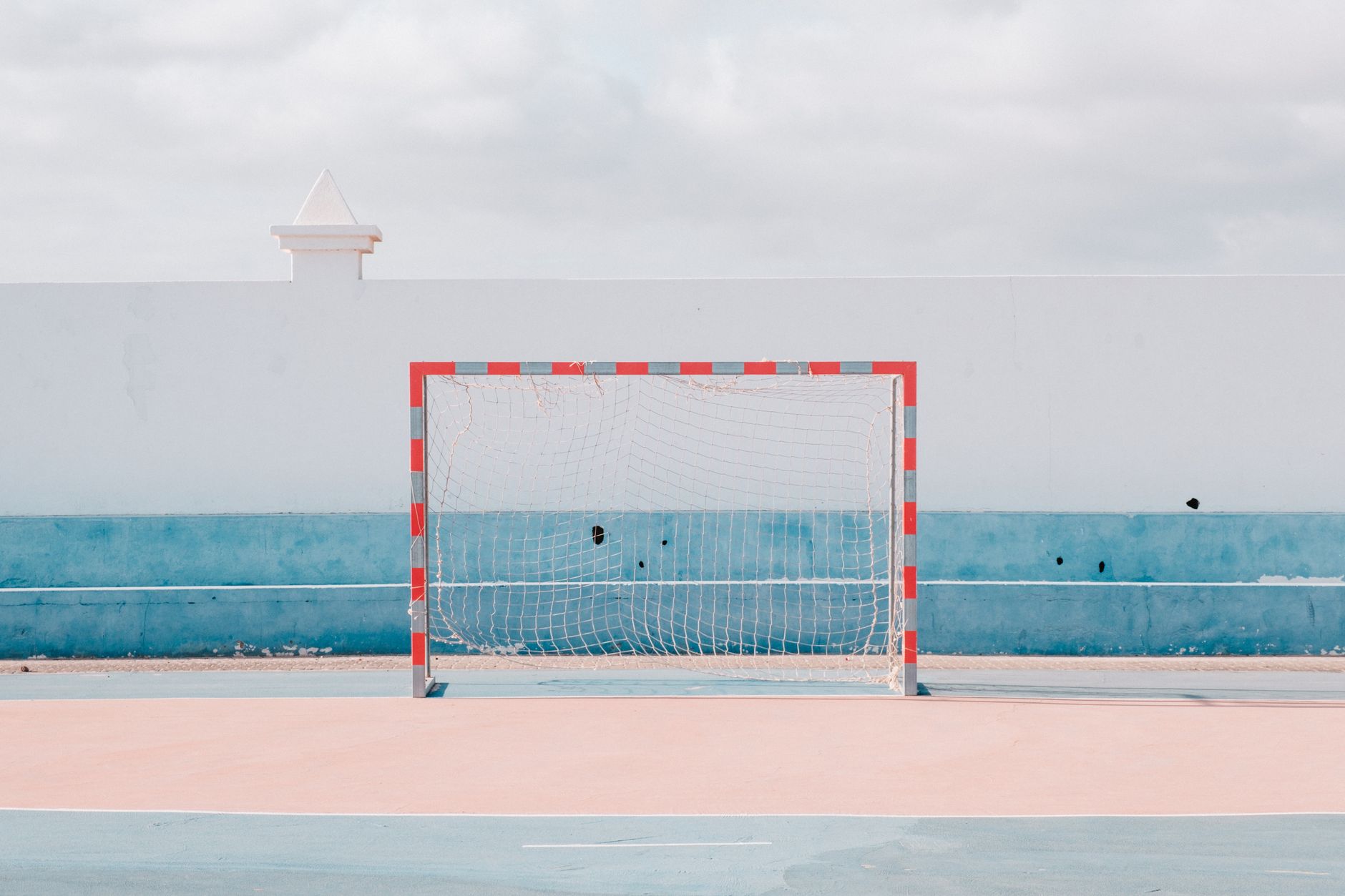 Bright sunny handball court with a vibrant goalpost. Perfect for sports or leisure themes