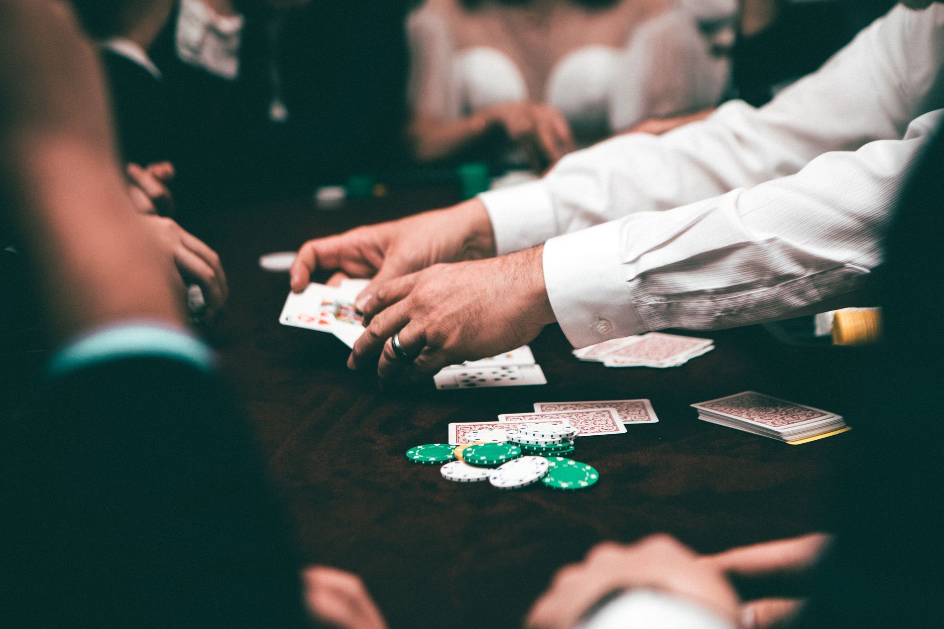 An intense poker game featuring players and poker chips on the table in an indoor setting
