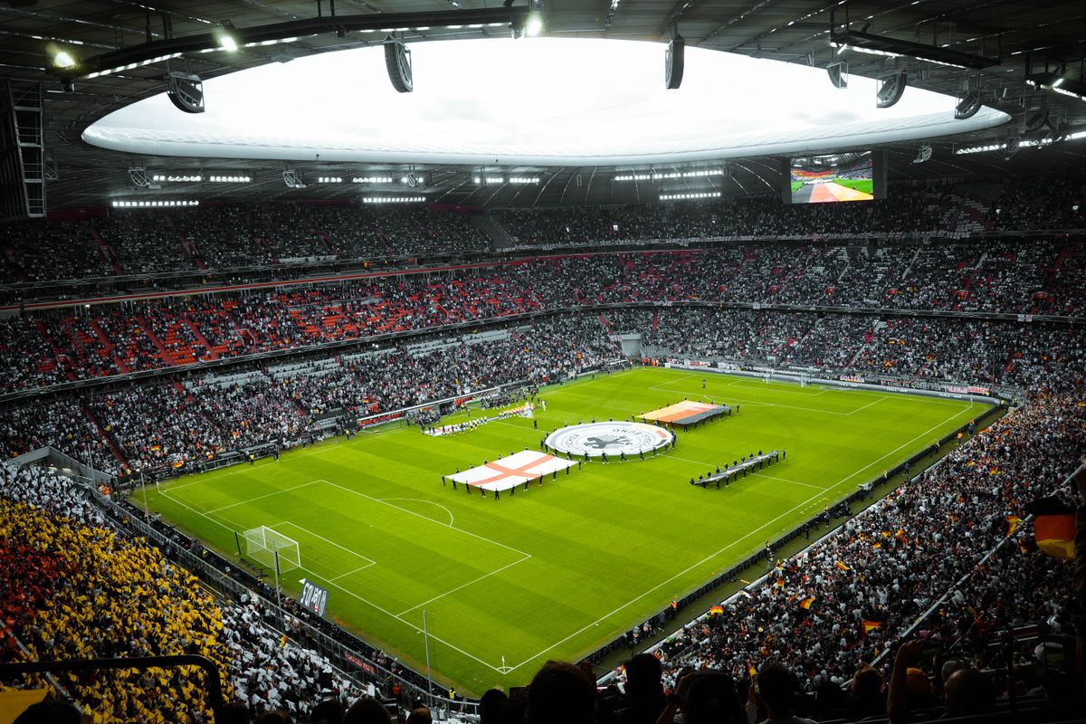 Packed football stadium during a pre-match ceremony on the pitch