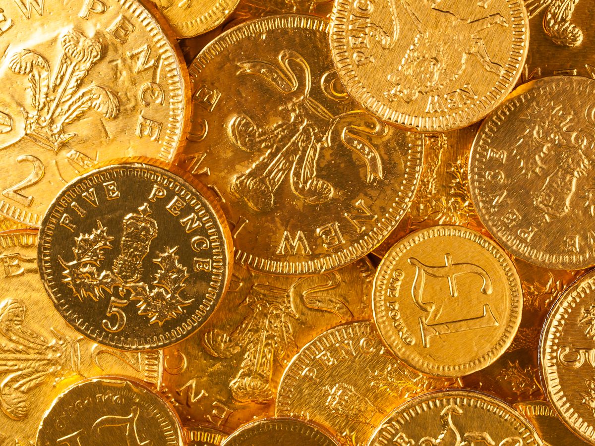 Pile of golden coins illuminated with warm light
