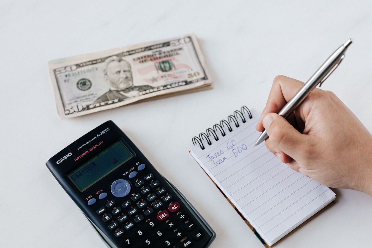 Person setting a limit with a phone timer and notebook beside them