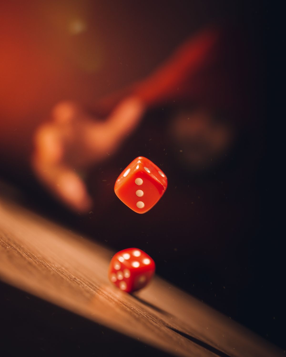 Three red dice captured mid-roll against a dark background