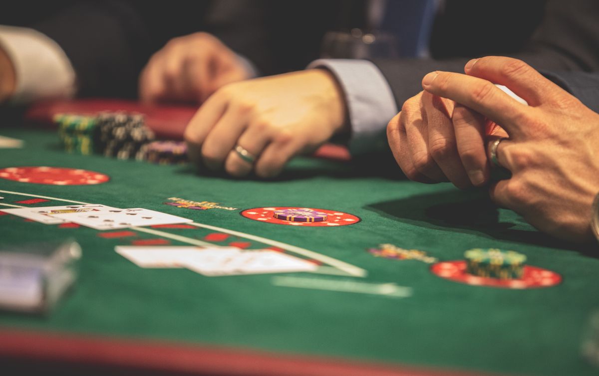 Casino chips and playing cards on a dark poker table with moody lighting