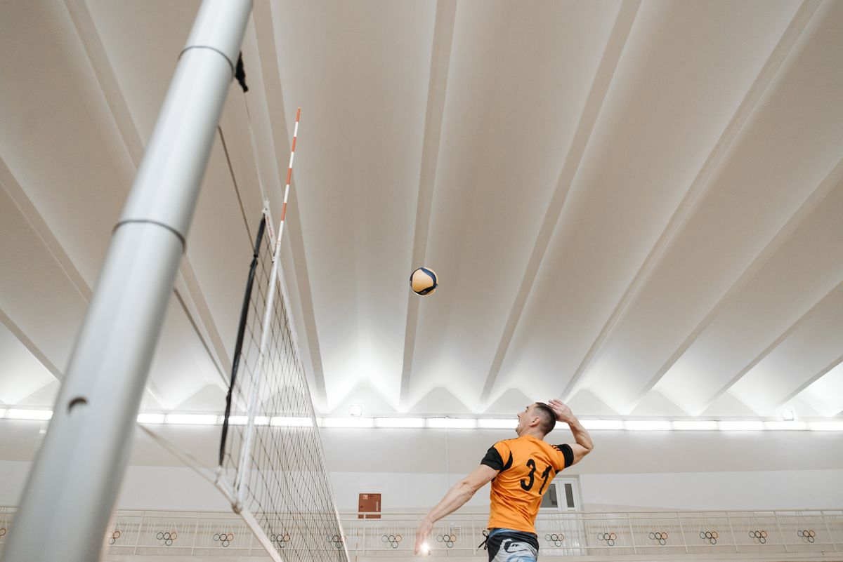 Volleyball player jumping to spike the ball over the net